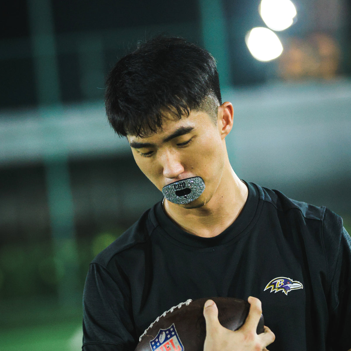 Real CHD mouthguard player photo — square composition — chd diamond silver on black football mouthguard