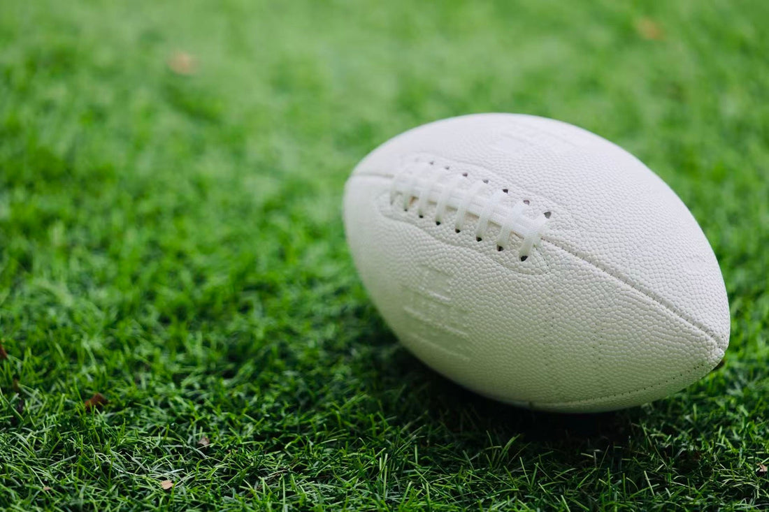 White football on turf showing white laces and textured panels