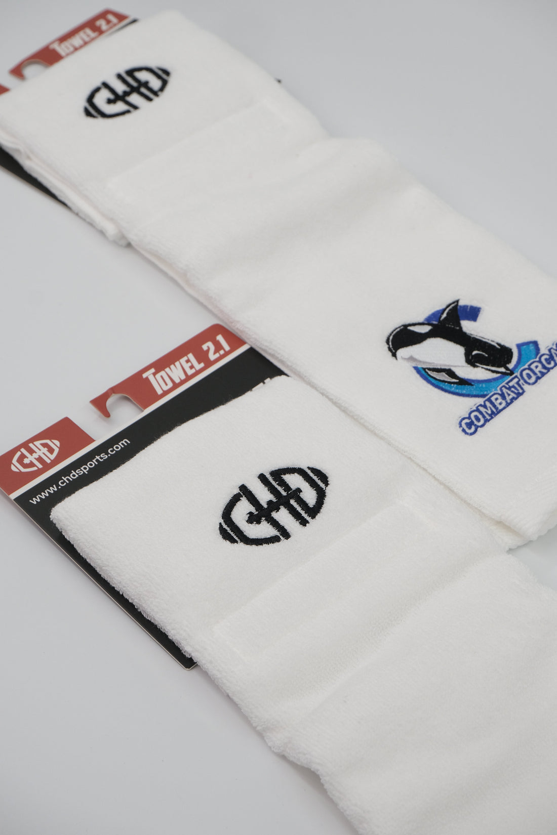 White CHD football towels with blue orca artwork and black CHD mark